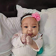 Niecey joined the competition — help win amazing prizes! baby, infant, face, headband, flower, hands, fist, pillow, bedding, onesie, clothing, pacifier, bed, portrait, cute, young_child, eyes, hair, skin, neutral_expression