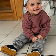 Manoa participe au concours pour gagner de l'argent avec cette photo : toddler, child, smiling, cap, backward_cap, maroon_sweatshirt, gray_pants, black_shoes, tiled_floor, indoor, happy, cute, sitting, hands, face, young_child, playful, casual_clothing, floor_tiles, home_interior