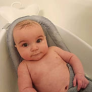 Ryan is registered to the contest to win money with this photo: arm, baby, bath, bathroom, bathtub, child, chubby, cute, expression, eyes, face, hand, indoors, infant, person, relaxing, seat, skin, towel, water