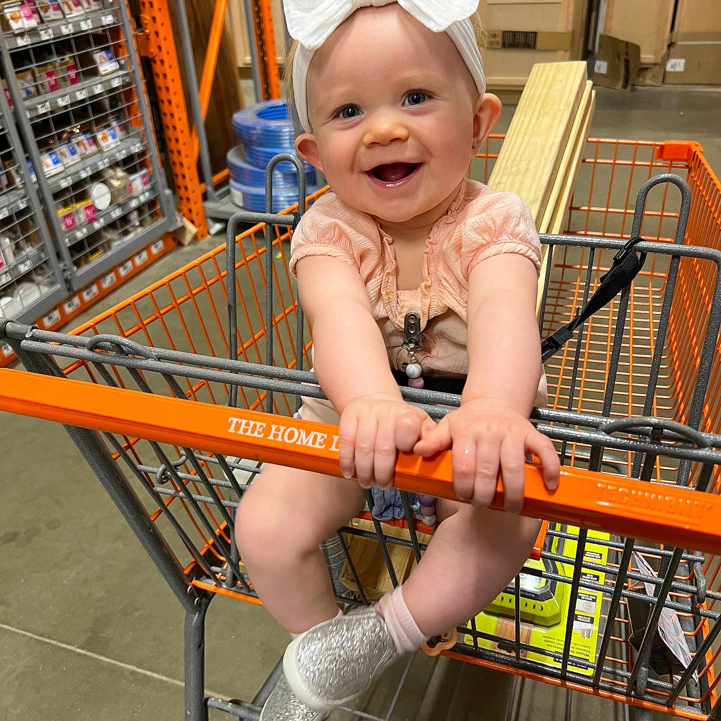 Veda is registered to the contest to win money with this photo: aisle, baby, babylaughing, clothing, face, footwear, grocerystore, happy, head, indoors, person, photography, portrait, pushing, shelf, shoe, shop, shopping, shoppingcart, smile