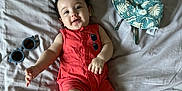 Peter joined the competition — help win amazing prizes! baby, infant, smiling, lying_down, bed, bedding, romper, clothing, hat, sunglasses, happy, cute, skin, person, indoor, child, young, relaxed, accessory, fashion