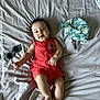 baby, infant, smiling, lying_down, bed, bedding, romper, clothing, hat, sunglasses, happy, cute, skin, person, indoor, child, young, relaxed, accessory, fashion