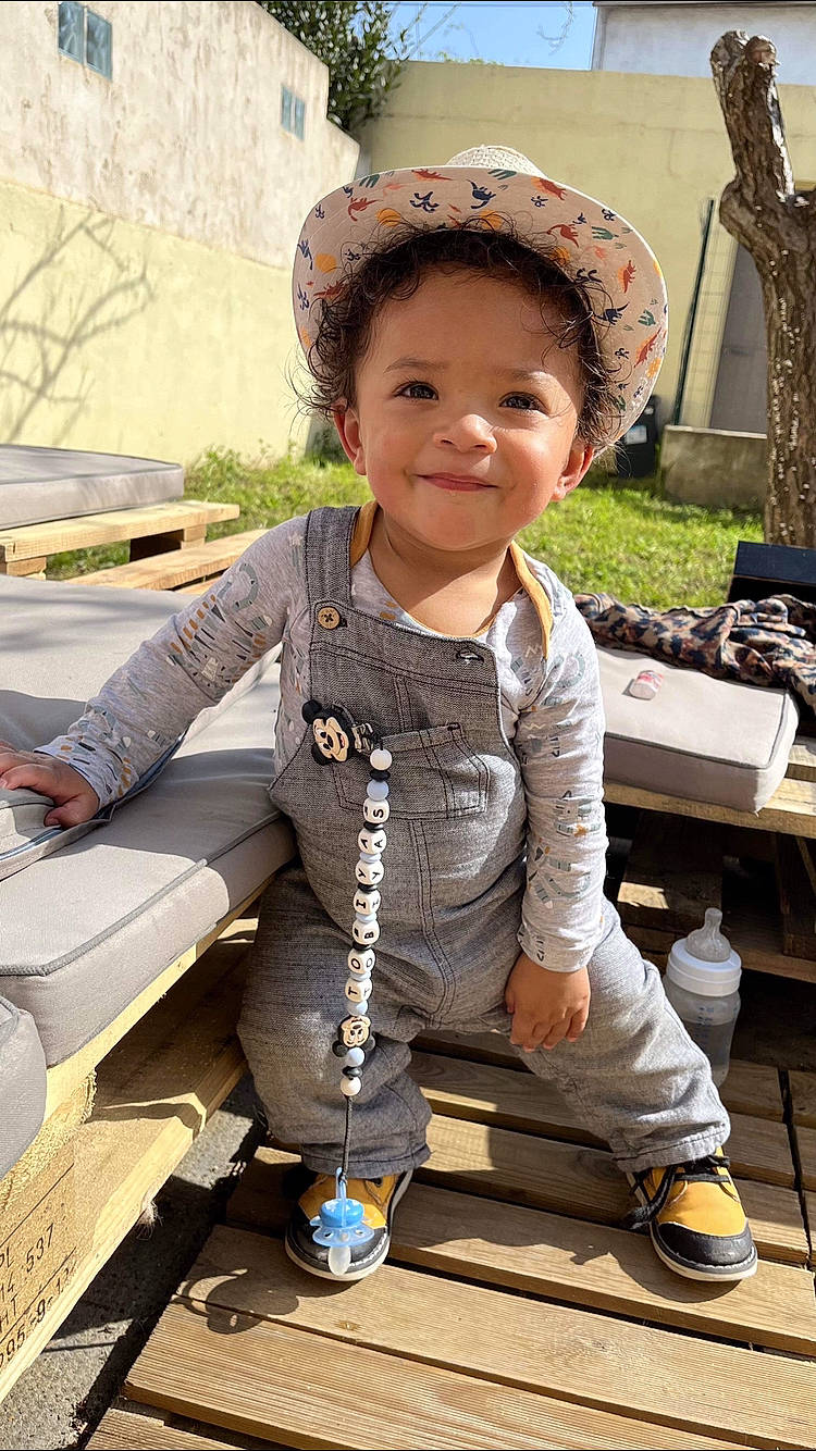 Tobiyas participe au concours pour gagner de l'argent avec cette photo : baby_toddler_clothing, cap, child, fashion_accessory, fun, grass, happy, joy, leisure, person, plant, recreation, shoe, sitting, sleeve, smile, snapshot, sneakers, street_fashion, toddler