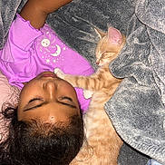 Simbah is registered to the contest to win money with this photo: child, kitten, cat, sleeping, blanket, bed, cozy, purple_shirt, paw, fur, indoors, resting, cute, nap, peaceful, friendship, soft_texture, human, pet, comfort