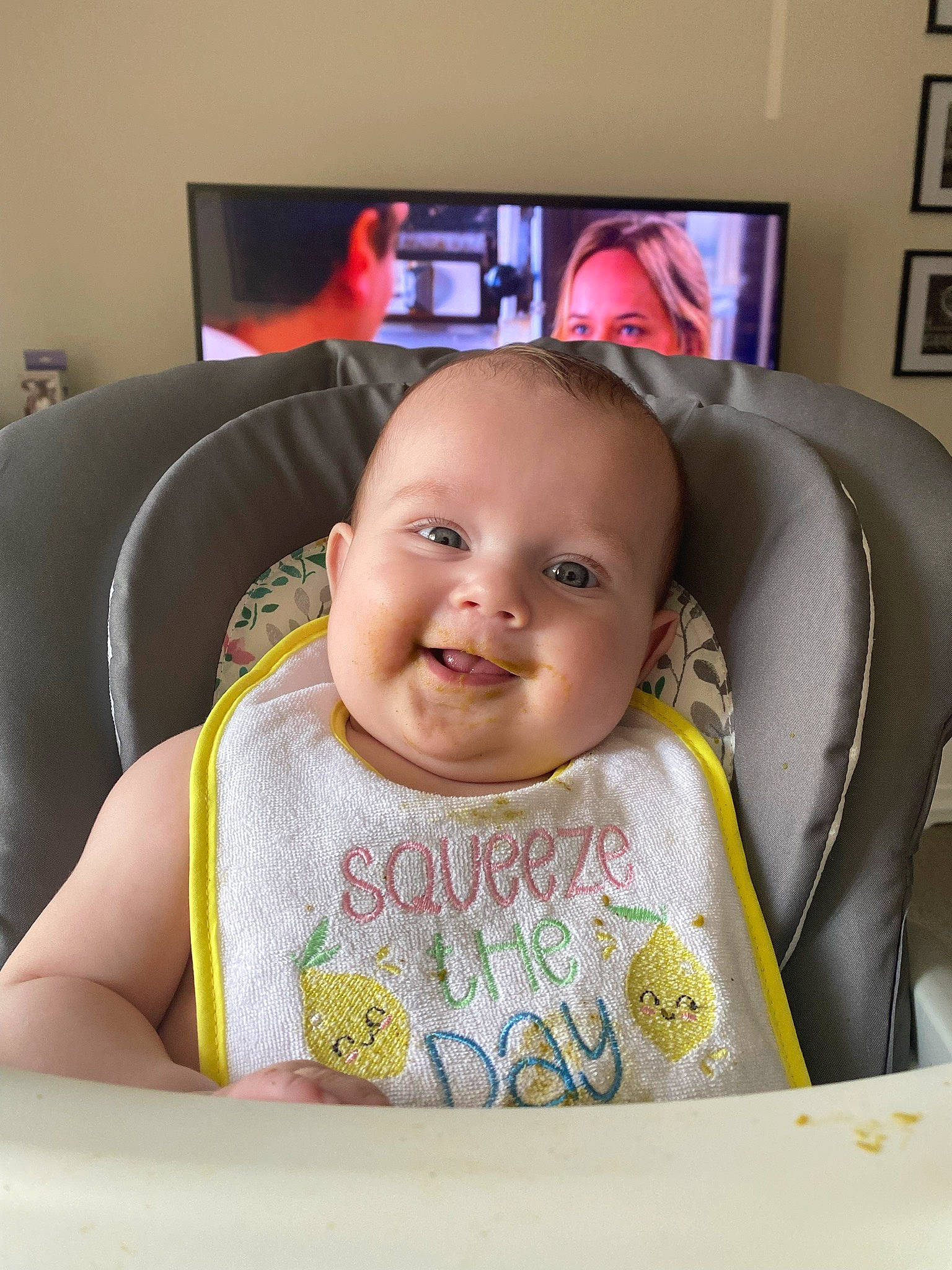 Amelia joined the competition — help win amazing prizes! baby, baby_products, baby_toddler_clothing, bib, cable_television, chair, cheek, child, comfort, couch, fun, happy, joy, person, picture_frame, room, sitting, smile, t_shirt, television