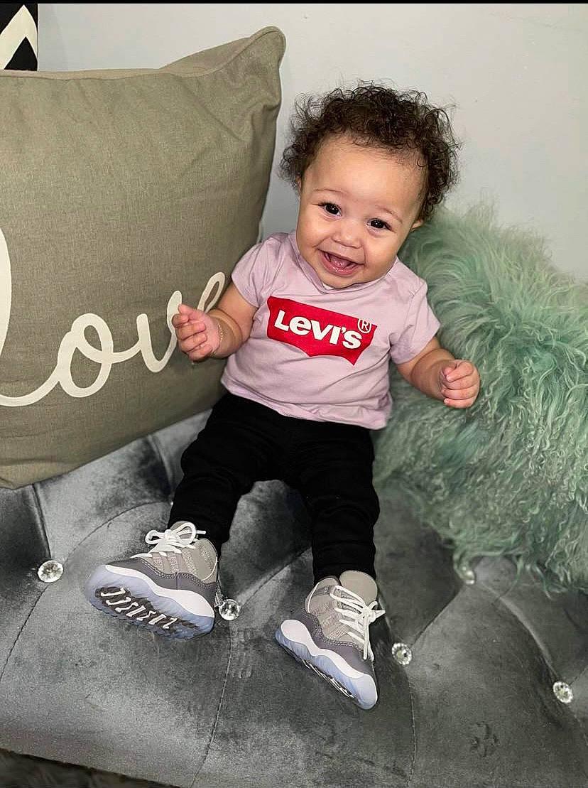 Kylee is registered to the contest to win money with this photo: baby, baby_toddler_clothing, child, comfort, couch, facial_expression, flash_photography, fun, gesture, grass, hairstyle, happy, person, shoe, sitting, sleeve, smile, sneakers, stock_photography, t_shirt