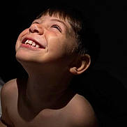 Thiago Alvarino joined the competition — help win amazing prizes! bare_shoulders, child, closeup, dark_background, emotion, expression, face, hair, happy, head, human, innocence, joy, light, looking_up, portrait, shadow, skin, smile, teeth