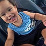 Esau is registered to the contest to win money with this photo: arm, black_shorts, blue_shirt, casual_clothing, child, curly_hair, cute, face, happy, indoor, joyful, leg, person, portrait, seatbelt, sitting, smiling, toddler, vehicle_seat, young_child