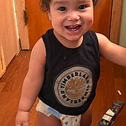 Esau joined the competition — help win amazing prizes! baby, black_shirt, child, clothing, curly_hair, cute, diaper, door, expression, floor, happy, home, indoor, person, smile, standing, timberland_logo, toddler, tooth, wooden_floor