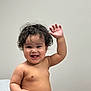 Esau is registered to the contest to win money with this photo: baby, bare_chest, child, curly_hair, cute, diaper, expression, friendly, happy, human, indoor, infant, joyful, person, portrait, sitting, skin, smiling, waving, young_child