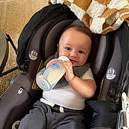 Statham joined the competition — help win amazing prizes! baby, infant, car_seat, milk_bottle, blanket, clothing, smiling, face, person, indoor, seatbelt, fabric, home, comfort, child, feeding, cute, young_child, happy, casual
