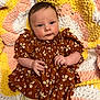 Daisy-Mae is registered to the contest to win money with this photo: baby, infant, child, dress, floral_pattern, ruffles, crocheted_blanket, yellow, pink, white, soft_texture, cute, lying_down, looking_at_camera, hands, legs, tights, bow, portrait, indoors