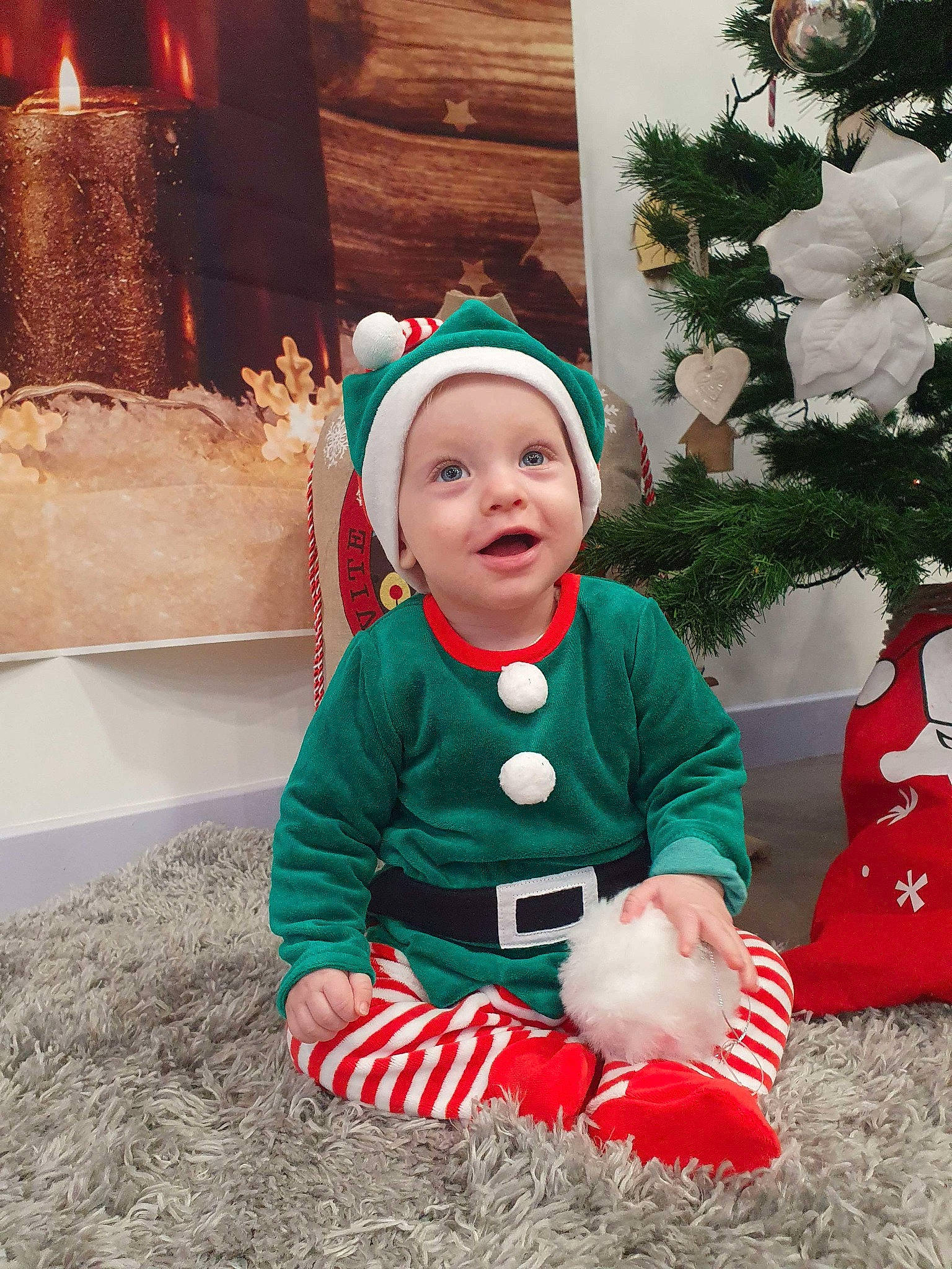 Benjamin participe au concours pour gagner de l'argent avec cette photo : baby, baby_toddler_clothing, christmas, christmas_decoration, christmas_eve, christmas_ornament, costume_hat, event, fictional_character, grass, happy, hat, headwear, holiday, holiday_ornament, human_body, person, plant, santa_claus, smile