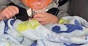 Giovanni joined the competition — help win amazing prizes! baby, infant, pacifier, blanket, hoodie, hat, car_seat, child, face, clothing, cute, young, indoors, comfort, bundle, warm, person, portrait, expression, baby_accessory