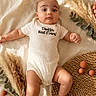 baby, blanket, brown_balls, casual, child, cute, decor, dried_grass, greenery, indoors, infant, lying_down, natural_light, onesie, peaceful, portrait, relaxing, sleepwear, soft_texture, woven_mat