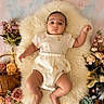 adorable, baby, basket, calm_expression, child, cozy, cute_outfit, decorative_plants, fairy_lights, flowers, fluffy_rug, indoors, infant, lying_down, newborn, pastel_colors, peach_pattern, portrait, soft_lighting, succulent