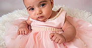 Myra is registered to the contest to win money with this photo: adorable, baby, child, closeup, curious, cute, expression, fashion, fluffy, indoor, infant, looking, pearls, person, pink_dress, portrait, seated, skin, soft_texture, young