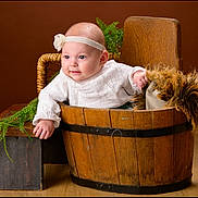 Nalya participe au concours pour gagner de l'argent avec cette photo : baby, infant, headband, wooden_bucket, bench, greenery, fur_pillow, white_outfit, portrait, studio, smile, chubby_cheeks, wooden_floor, prop, hand, eyes, cute, rustic, brown_background, basket
