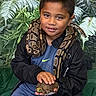 George joined the competition — help win amazing prizes! child, boy, snake, turtle, reptile, wildlife, animal, portrait, outdoor, jungle, foliage, nature, smiling, sitting, holding, pet, wild_animal, clothing, black_jacket, blue_shirt
