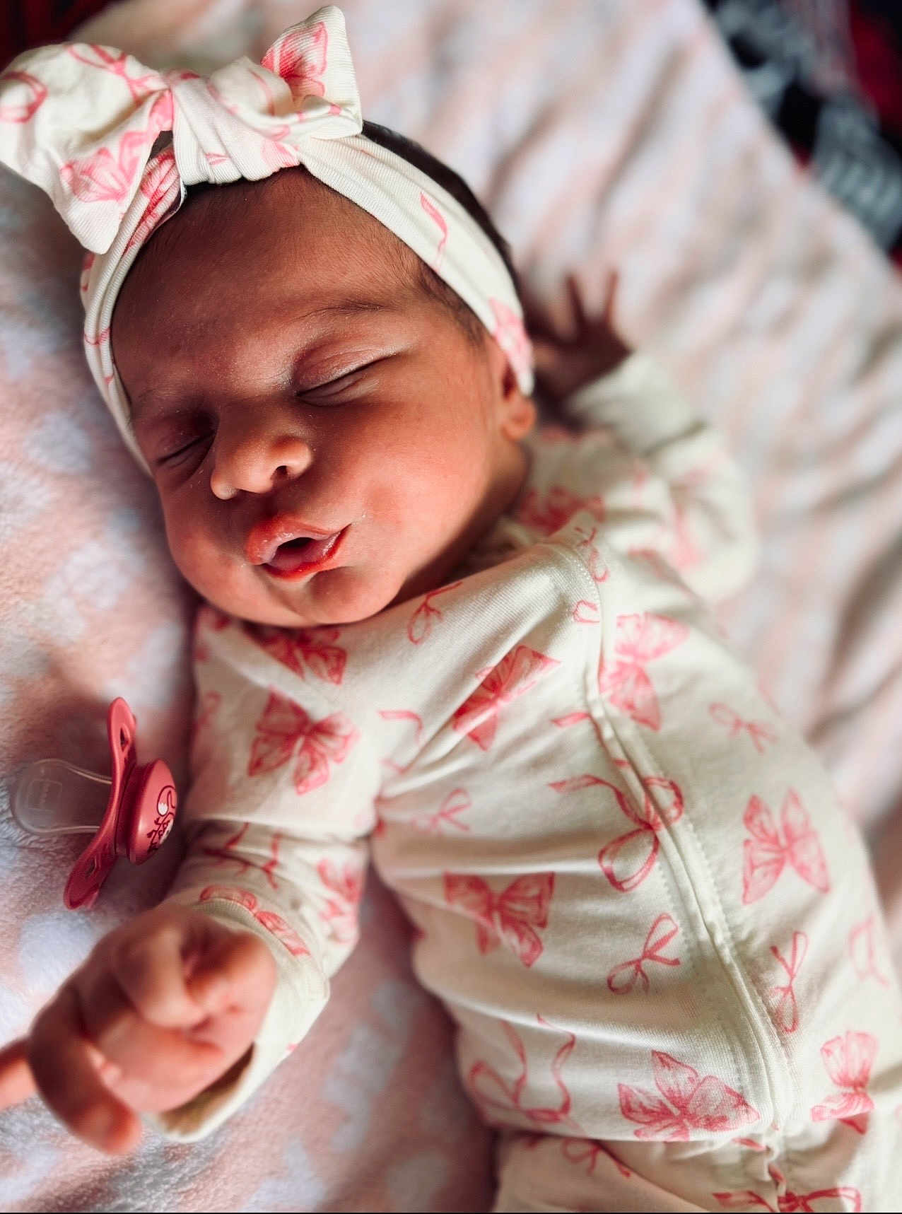 Vanessa is registered to the contest to win money with this photo: newborn, baby, sleeping, onesie, headband, pink, bow, pacifier, blanket, closeup, infant, peaceful, cute, soft, cozy, hand, face, clothing, portrait, indoor