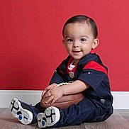 Felix is registered to the contest to win money with this photo: americanfootball, americanfootballball, baby, ball, clothing, face, football, happy, head, jeans, pants, person, photography, portrait, sitting, sleeve, smile, soccer, soccerball, sport