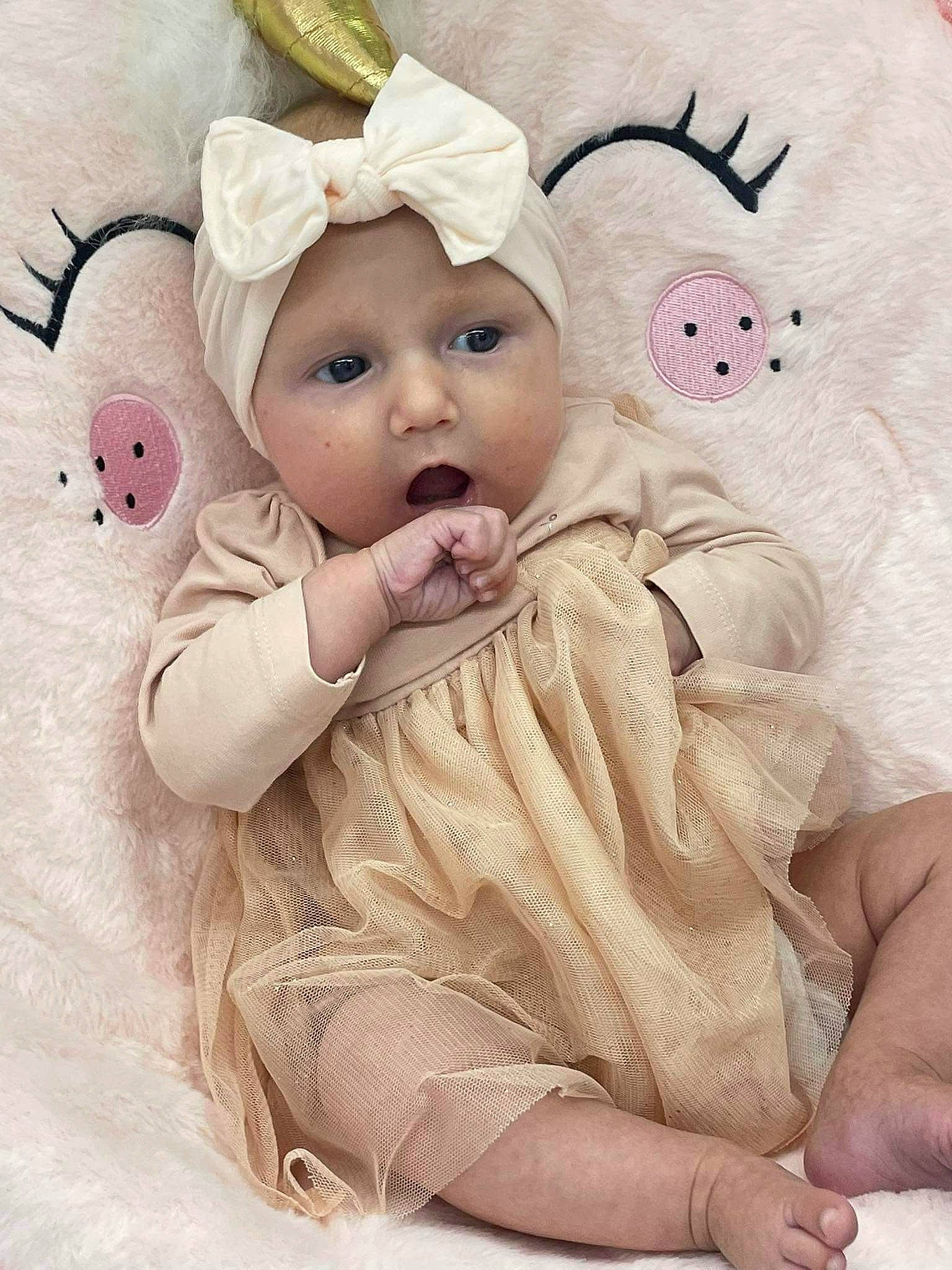 Cataleyah participe au concours pour gagner de l'argent avec cette photo : baby, baby_toddler_clothing, cap, comfort, costume_hat, ear, eyelash, face, happy, head, headgear, headpiece, headwear, linens, lip, person, picture_frame, pink, skin, sleeve