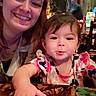 child, toddler, woman, smiling, happy, table, indoor, person, face, clothing, pattern, hand, hair, portrait, family, dining, cute, casual, people, restaurant