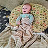 Mateo is registered to the contest to win money with this photo: baby, blanket, pillow, couch, cushion, child, smiling, face, comfort, indoor, furniture, woodland_animals, pattern, soft_texture, happy, lying_down, infant, warm, cozy, home