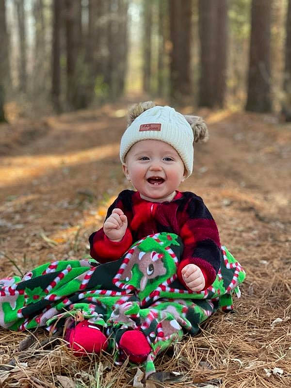 Ashlyn is registered to the contest to win money with this photo: baby, baby_toddler_clothing, child, face, forest, grass, happy, head, headwear, jacket, leaf, outerwear, people_in_nature, person, plant, recreation, smile, soil, spring, toddler