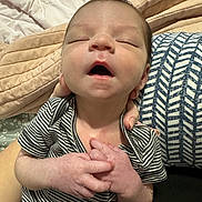 Charlie joined the competition — help win amazing prizes! baby, newborn, infant, sleeping, yawning, onesie, striped_clothing, hands, adult_hand, blanket, pillow, bed, face, mouth_open, portrait, closeup, skin, cozy, nursery, sleepy