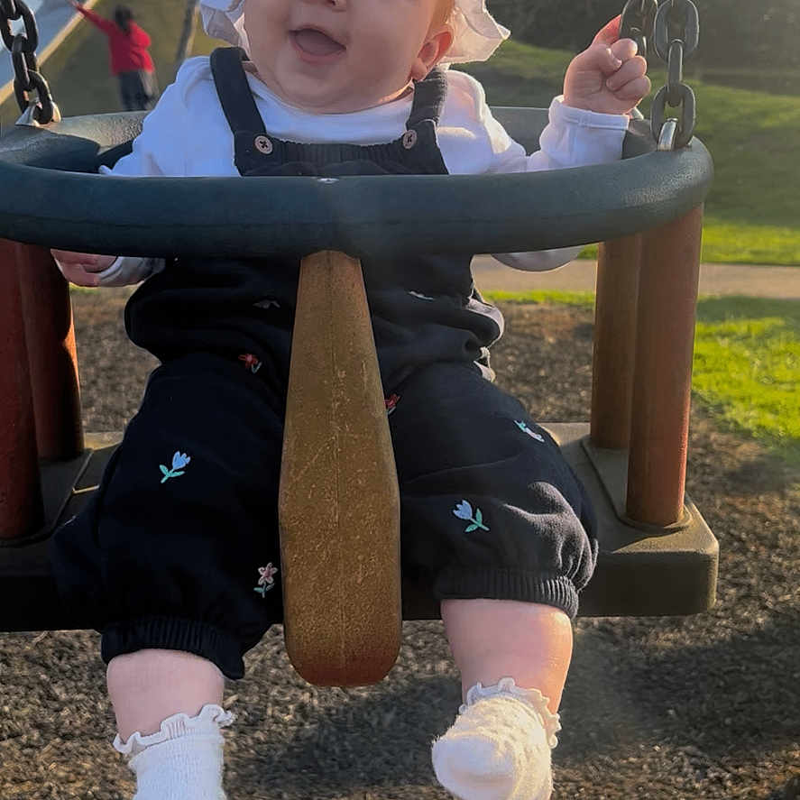 Elsie-Mae joined the competition — help win amazing prizes! baby, child, clothing, cute, daylight, fun, grass, happy, infant, outdoor, park, person, play, playground, seat, smiling, sunhat, sunlight, swing, trees