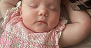 Elsie-Mae is registered to the contest to win money with this photo: baby, sleeping, pink_dress, cherry_embroidery, arm, blanket, leopard_print, face, infant, closeup, resting, soft_surface, cute, child, peaceful, portrait, skin, head, indoors, relaxing