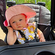 Addison joined the competition — help win amazing prizes! baby, child, stroller, hat, sunhat, outdoor, greenery, sunlight, summer, sunflower_dress, seatbelt, cute, infant, person, portrait, expression, hand, nature, daylight, relaxing
