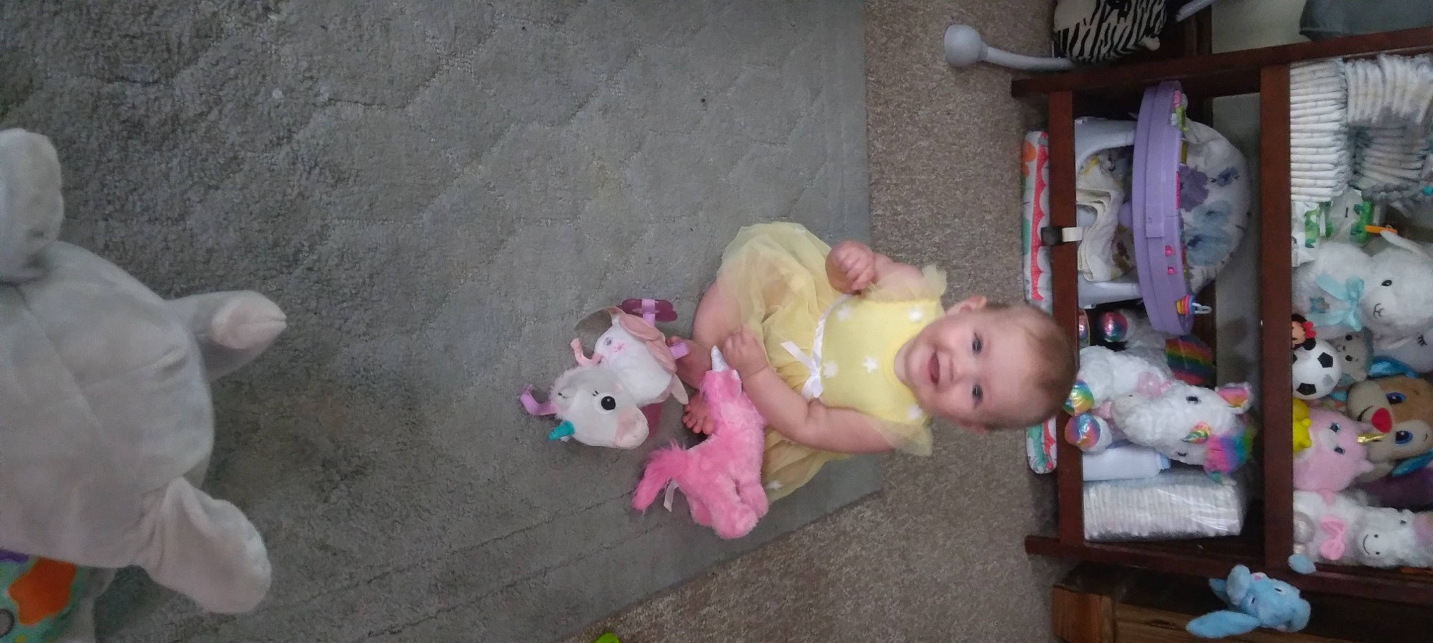 Ava is registered to the contest to win money with this photo: baby, baby_products, baby_toddler_clothing, baby_toys, cheek, child, doll, flooring, fun, joy, person, pink, room, sitting, stuffed_toy, toddler, toy, wood