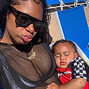 Demetrius joined the competition — help win amazing prizes! woman, child, toddler, sleeping, sunglasses, black_top, red_shirt, checkered_pattern, blue_chair, outdoor, sunlight, portrait, relaxation, poolside, daylight, curly_hair, necklace, skin, hand, casual