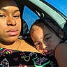 Demetrius is registered to the contest to win money with this photo: woman, child, car, sunlight, braids, closeup, portrait, window, seat, clothing, patterned_top, skin, face, hand, family, intimate, casual, daylight, relaxed, together