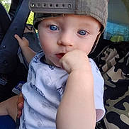 Hunter joined the competition — help win amazing prizes! child, toddler, blue_eyes, cap, backwards_cap, white_shirt, car_prints, hand, fist, vehicle_interior, seat, adult, camouflage, curious, close_up, person, portrait, indoor, holding, baby