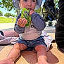 Milo is registered to the contest to win money with this photo: toddler, child, outdoor, sun_hat, snack, food_pouch, sitting, blanket, stroller, trees, sunlight, park, shorts, long_sleeve_shirt, barefoot, person, daylight, shade, happy, play