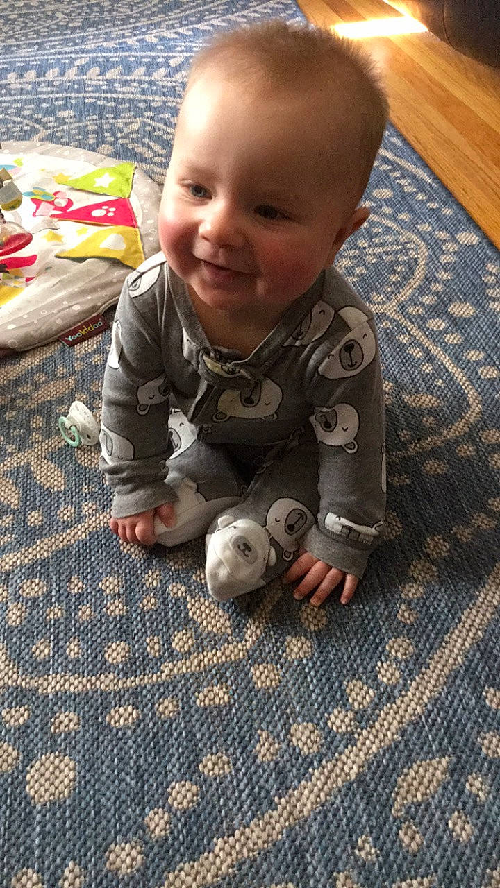 Hudson is registered to the contest to win money with this photo: baby, baby_toddler_clothing, cheek, child, crawling, eye, finger, floor, flooring, fun, happy, hardwood, head, joy, nose, organ, pattern, person, skin, smile