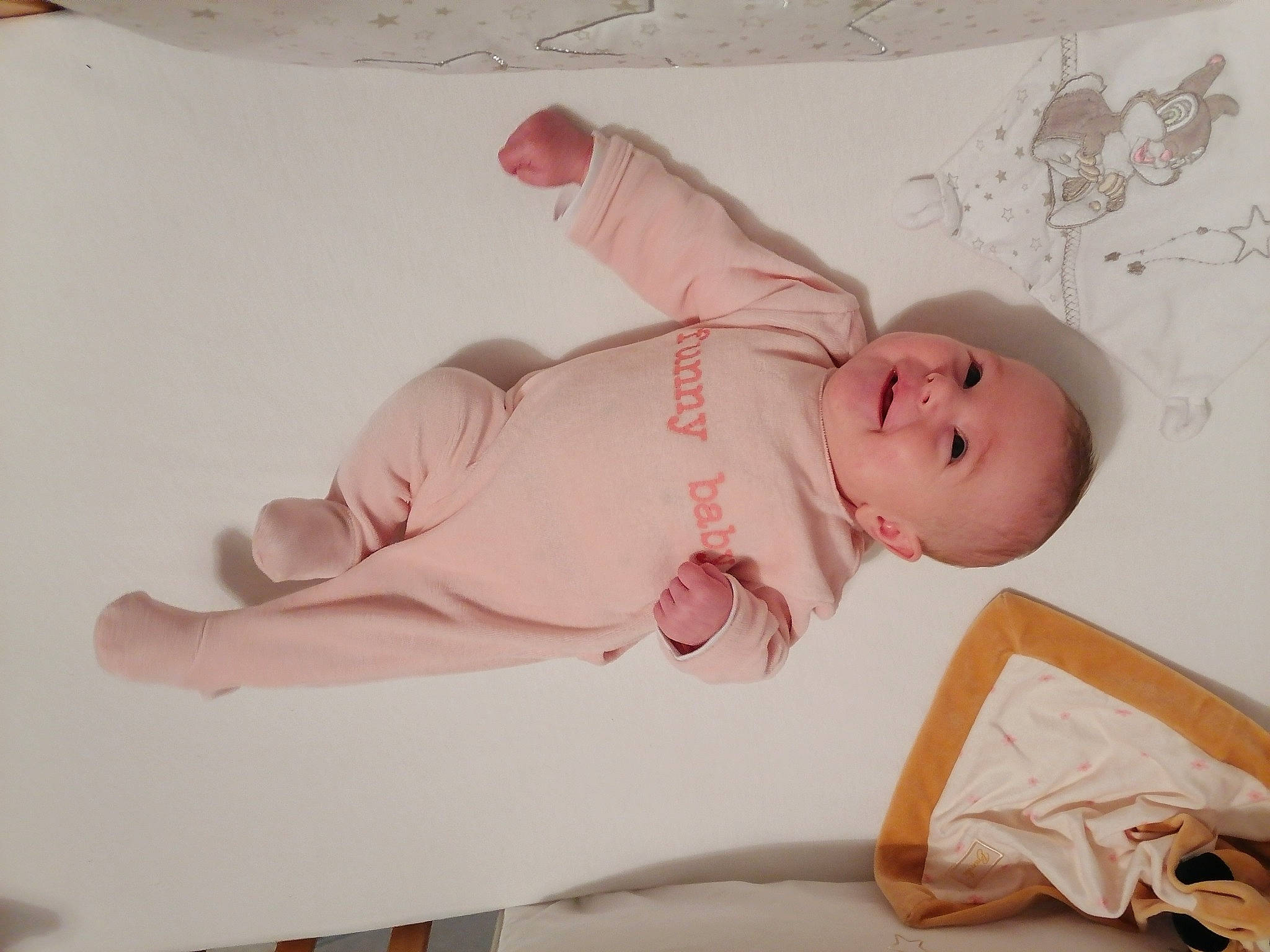 Rose participe au concours pour gagner de l'argent avec cette photo : baby, baby_products, baby_safety, baby_sleeping, baby_toddler_clothing, bedding, child, comfort, dress, eye, finger, hat, linens, pattern, person, pink, room, skin, sleeve, smile