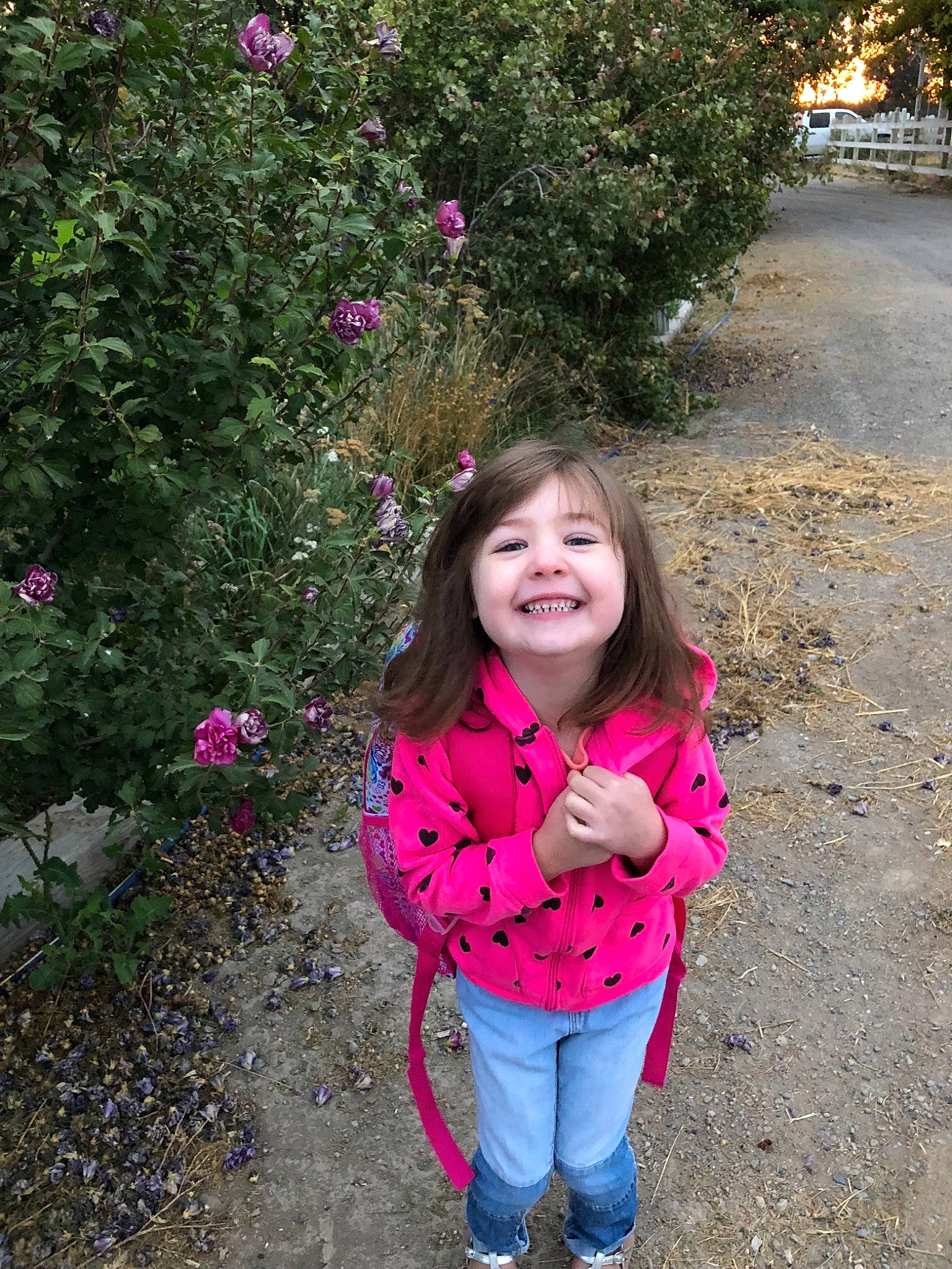Stella is registered to the contest to win money with this photo: child, day, emotion, facial_expression, flora, flower, fun, garden, girl, grass, joy, leaf, person, pink, plant, play, shrub, smile, spring, toddler
