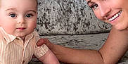 Matteo is registered to the contest to win money with this photo: baby, child, woman, smile, bracelets, tattoo, couch, plush, face, arm, shirt, person, indoor, family, happy, curly_hair, watch, jewelry, portrait, skin
