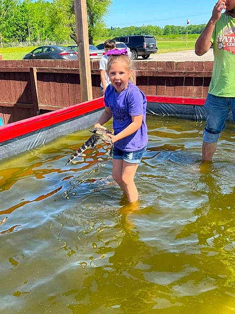 Allie is registered to the contest to win money with this photo: boats_and_boating_equipment_and_supplies, body_of_water, car, electric_blue, fun, lake, leisure, nature, outdoor_recreation, person, play, recreation, shorts, sky, smile, t_shirt, tree, vehicle, water, water_transportation