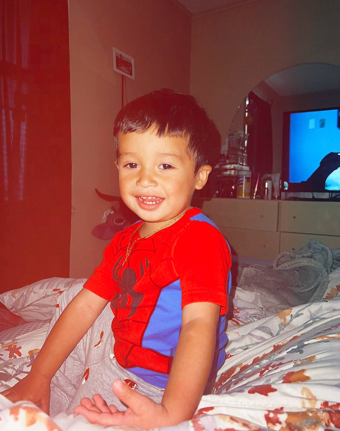 Aidan is registered to the contest to win money with this photo: baby_toddler_clothing, child, comfort, display_device, event, fun, happy, holiday, joy, lap, linens, party, person, play, room, sitting, smile, t_shirt, television, television_set