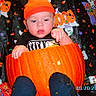 baby, infant, child, pumpkin, halloween, orange_hat, black_clothing, sitting, portrait, face, hands, curious, surprised, colorful, patterned_blanket, spooky, cartoon, indoor, date_stamp, seasonal