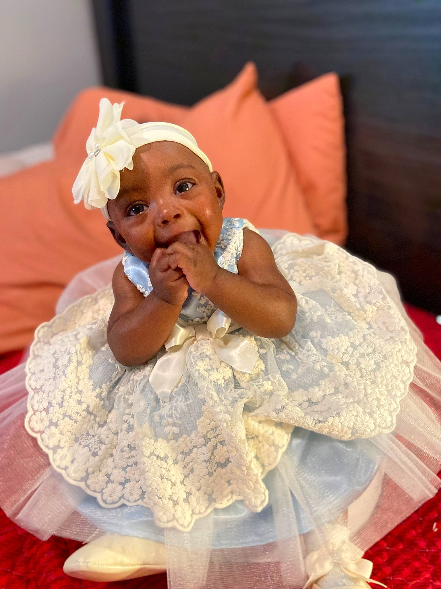 Mylah is registered to the contest to win money with this photo: baby, baby_toddler_clothing, child, comfort, couch, embellishment, event, finger, fun, gesture, happy, headpiece, headwear, linens, peach, person, pink, skin, smile, textile
