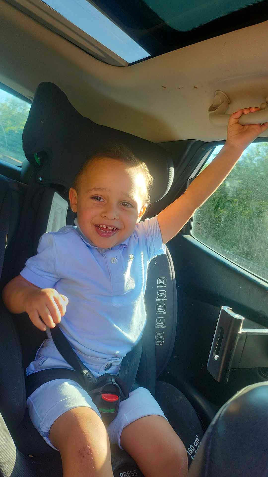 Sirat a rejoint le concours — aidez-le/la à gagner de superbes lots ! child, car_seat, smiling, seatbelt, sunlight, car_interior, happy, young_boy, clothing, shorts, polo_shirt, safety, window, hand, face, seat, vehicle, kid, portrait, daylight