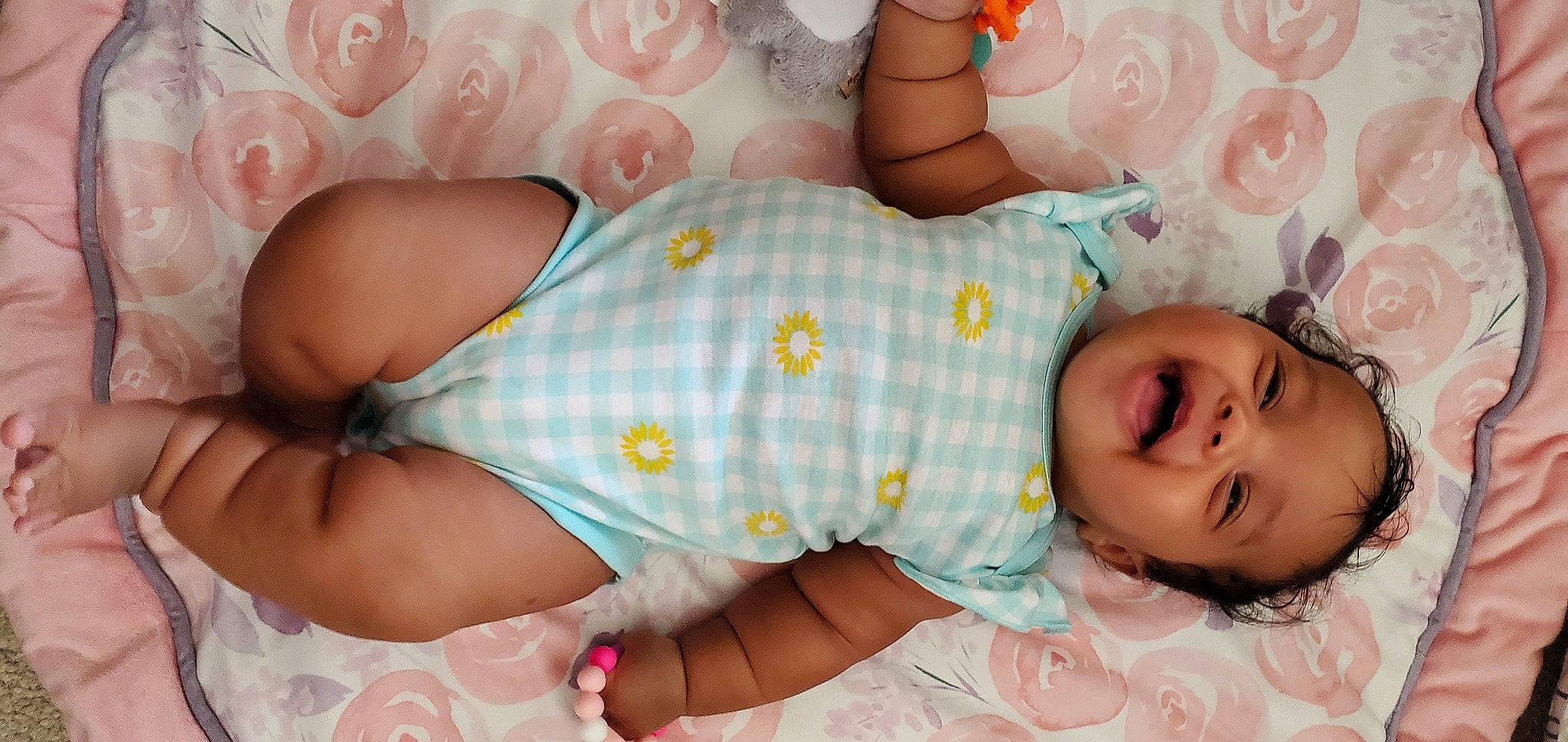 Arabella is registered to the contest to win money with this photo: arm, baby, baby_toddler_clothing, child, comfort, eyelash, finger, human_body, mouth, muscle, neck, orange, pattern, person, pink, product, skin, smile, textile, thigh