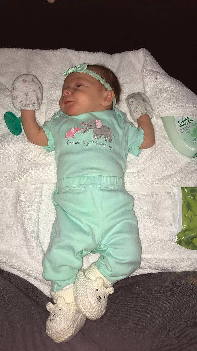 Elliana joined the competition — help win amazing prizes! baby, baby_products, baby_toddler_clothing, child, comfort, foot, fun, green, hat, linens, mechanical_fan, pattern, person, product, room, sitting, sleeve, sock, t_shirt, thumb