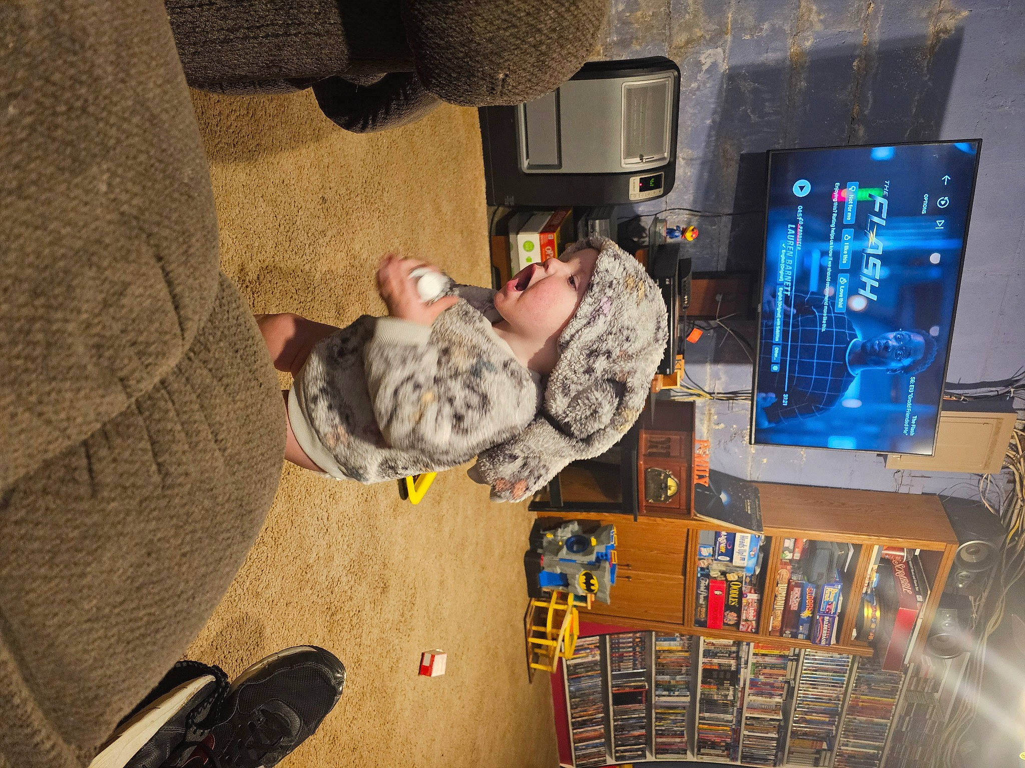 Thea is registered to the contest to win money with this photo: audio_equipment, child, comfort, computer_hardware, display_device, flooring, foot, fun, gadget, games, headwear, human_leg, machine, outdoor_shoe, person, play, recreation, room, television_set, tree